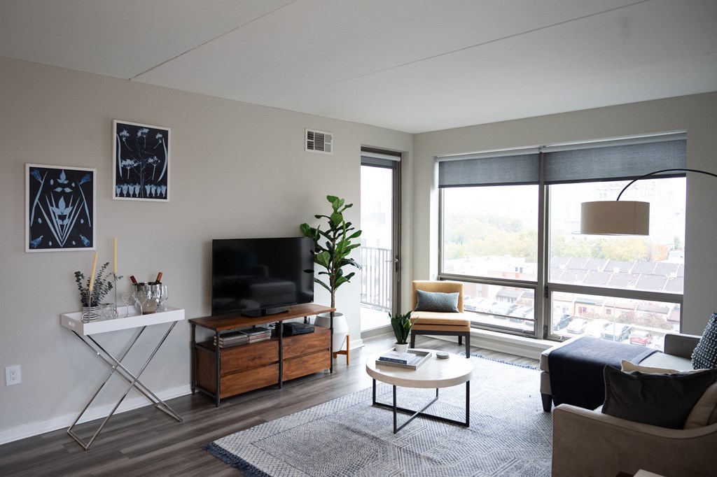 an apartment living room with a large window and a view of the city
