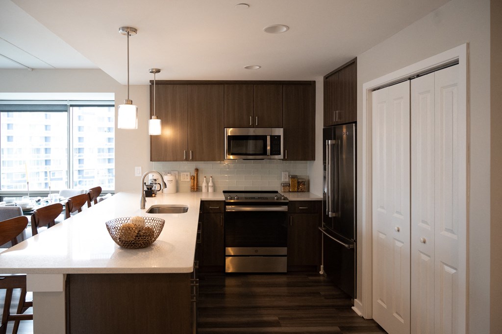 a kitchen with dark wood cabinets and a white counter top