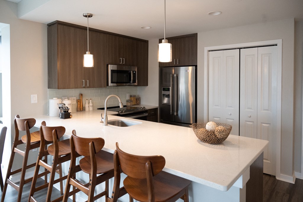 a kitchen with a large island and wooden chairs