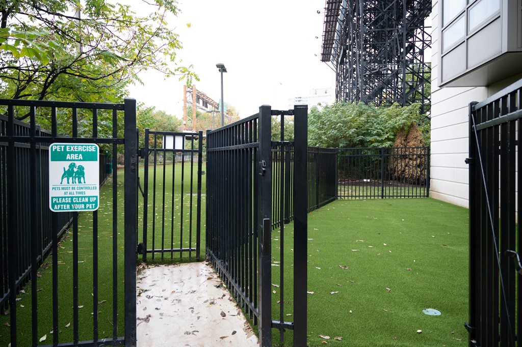 a gate with a sign that says dog park in front of a building