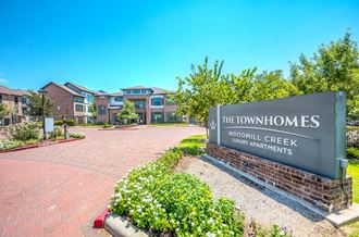 an image of the front of the townhomes at woodland creek apartments - Photo Gallery