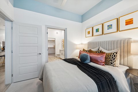 a bedroom with a bed and a door to a bathroom