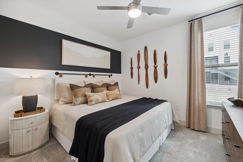 a bedroom with a bed and a ceiling fan