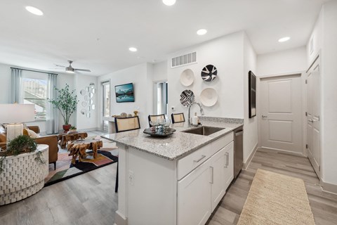 A modern kitchen with white cabinets and a large island.