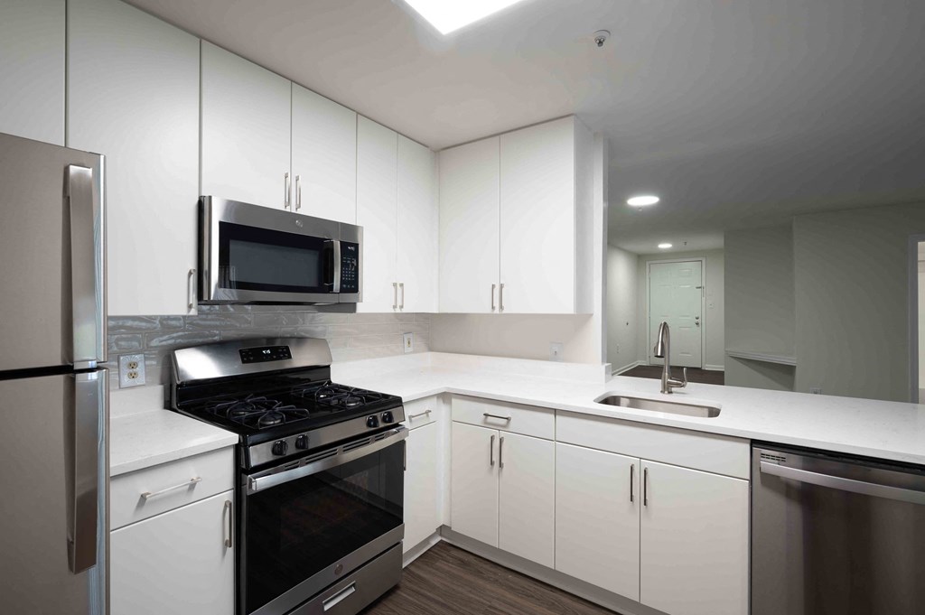 a kitchen with white cabinets and stainless steel appliances