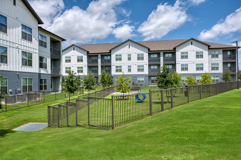 A large grassy area in front of apartment buildings.