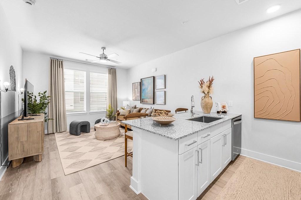 A kitchen with a white countertop and a wooden floor.