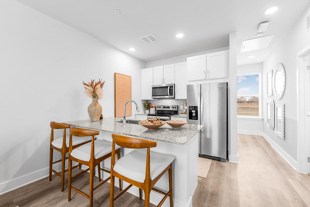 A kitchen with a table and chairs.