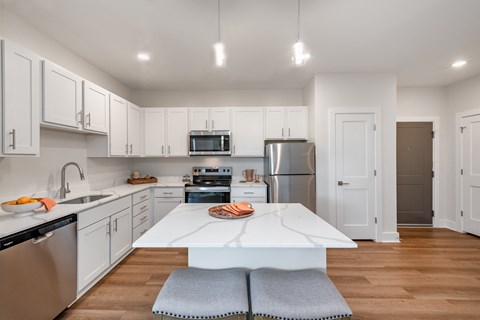 a white kitchen with stainless steel appliances and a white counter top