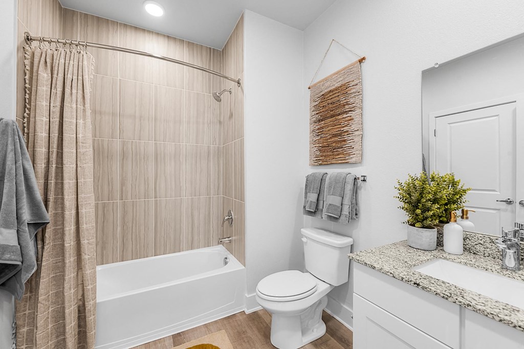 A bathroom with a toilet, sink, and shower.
