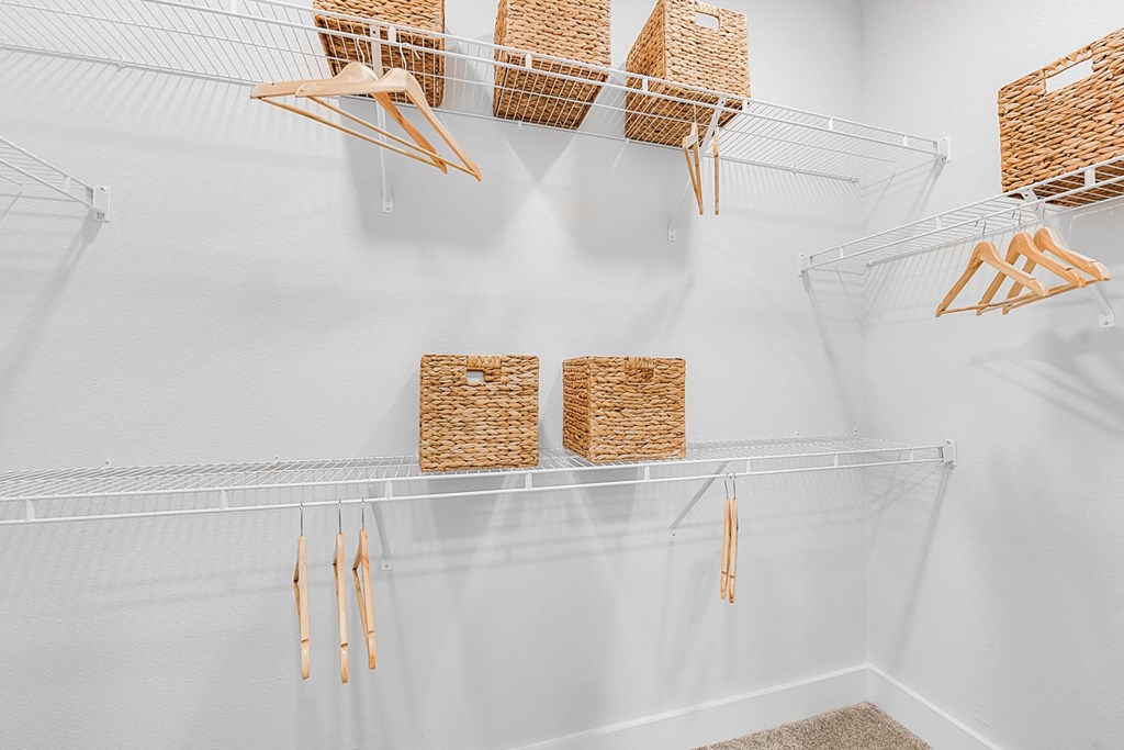 A white wall with baskets hanging on it.