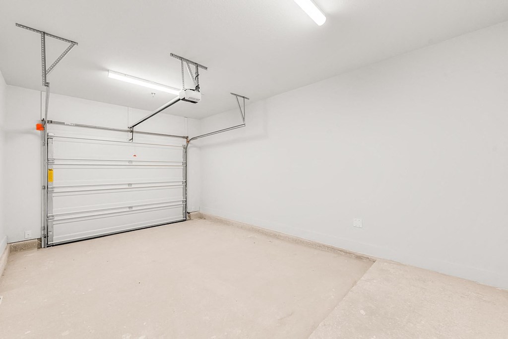 A white wall with a garage door opener.