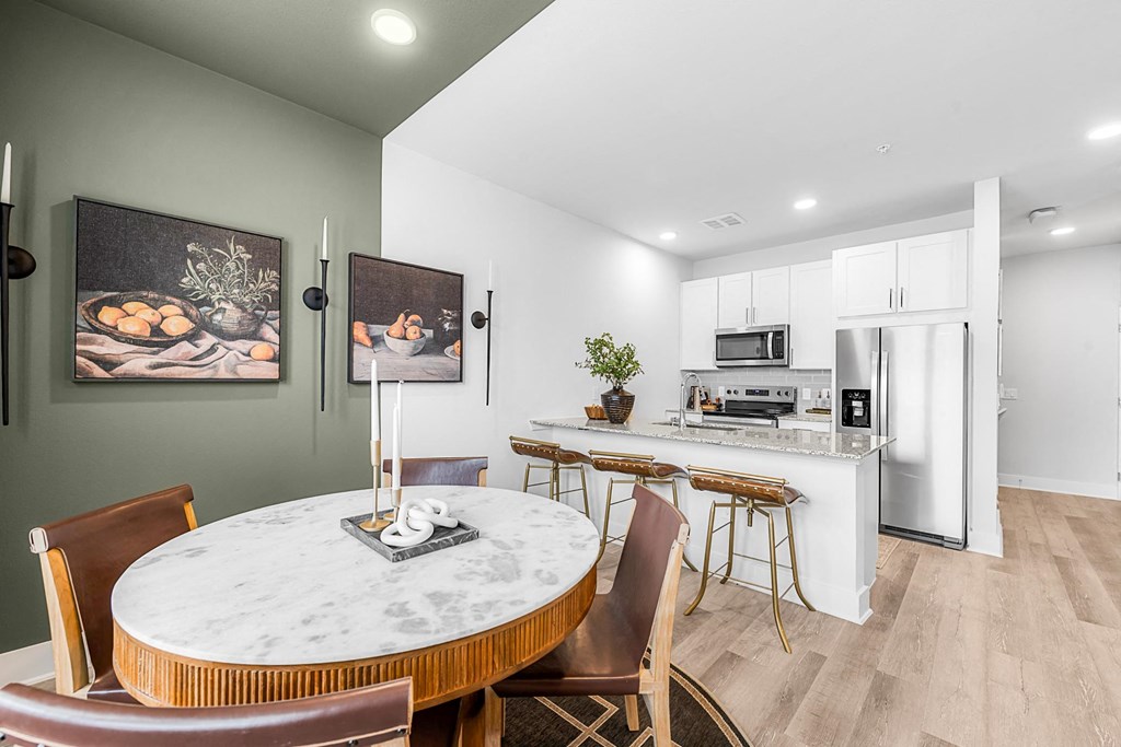 A modern kitchen with a dining table and chairs.