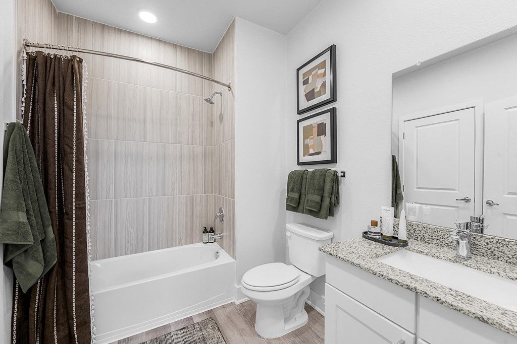 A white toilet sits next to a bathtub in a bathroom.
