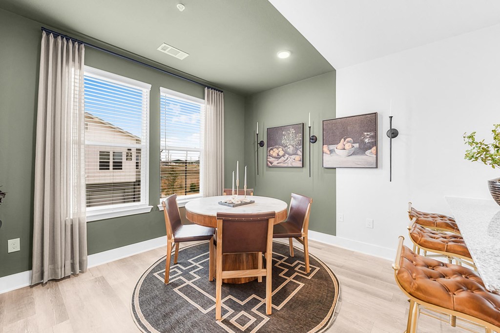 A dining room with a round table and chairs.