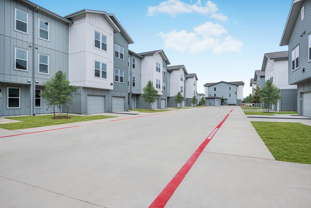 A row of houses with a red line down the middle of the street.