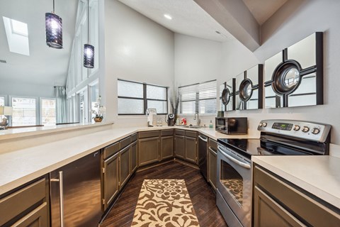 A modern kitchen with dark wood cabinets and stainless steel appliances.
