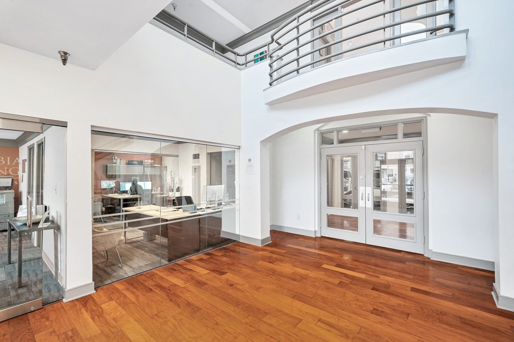 a living room with a hard wood floor and a balcony