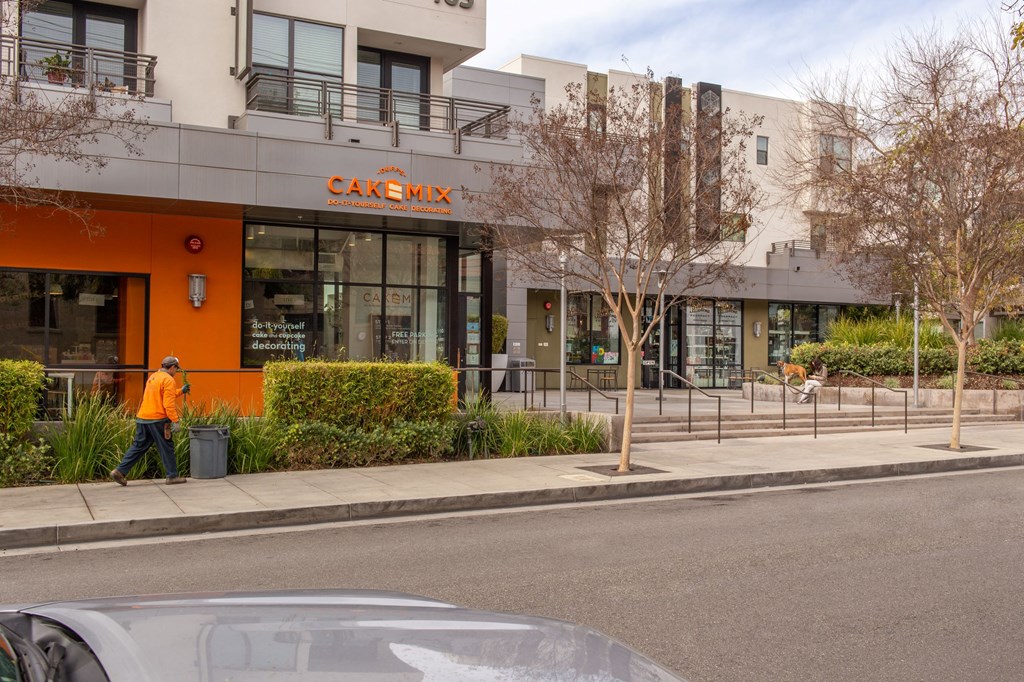 a man walking down the sidewalk in front of a building
