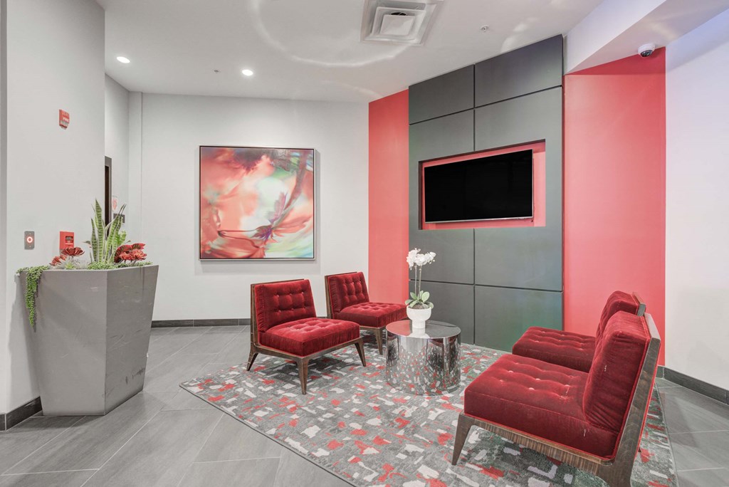 a living room with red chairs and a television