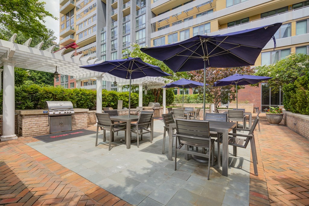 a patio with tables and chairs and umbrellas