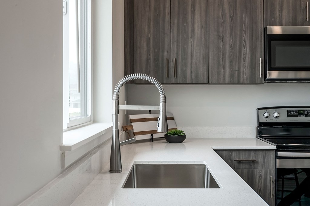 a kitchen counter with a sink and a silver faucet