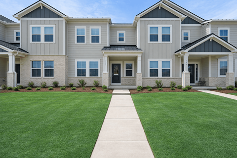 A row of houses with a green lawn in front.