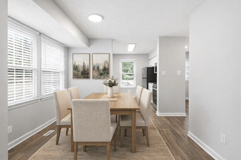 A dining room with a table and chairs.