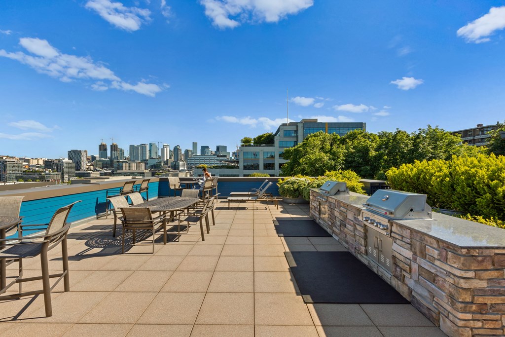 an outdoor terrace with tables and chairs and a pool with a cityscape in the background  at Dexter Lake Union, Seattle