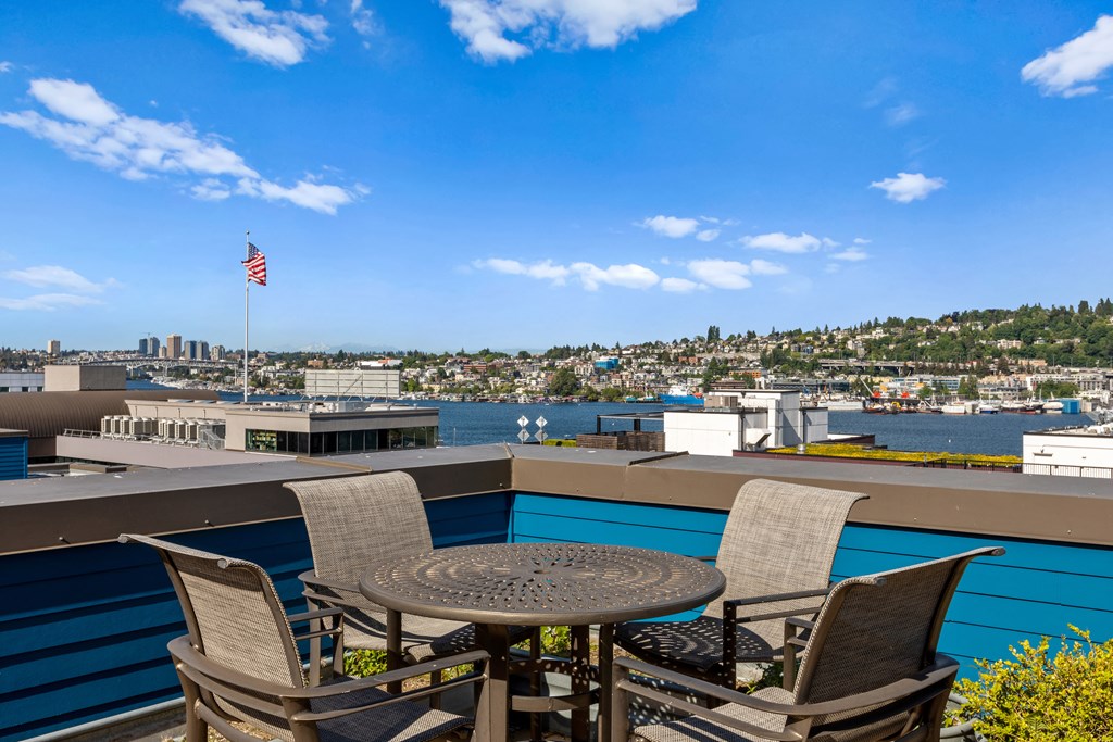 a patio with a table and four chairs overlooks a body of water  at Dexter Lake Union, Seattle, WA, 98109