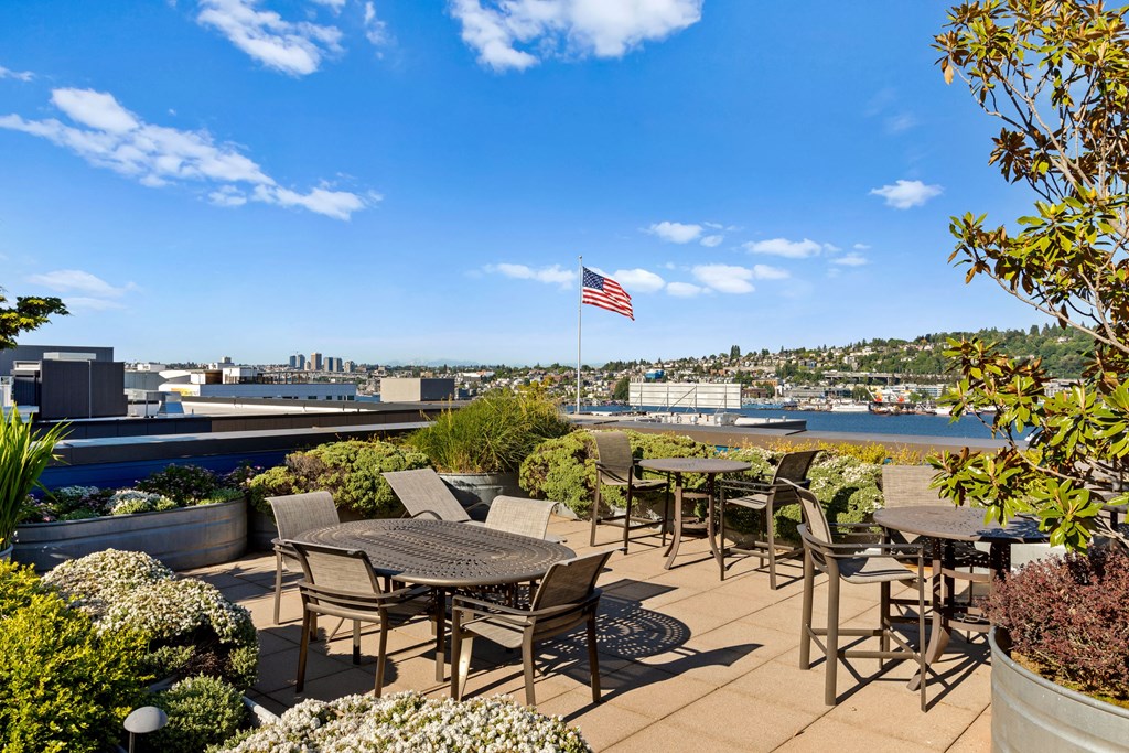 an outdoor patio with tables and chairs and an american flag  at Dexter Lake Union, Seattle, WA