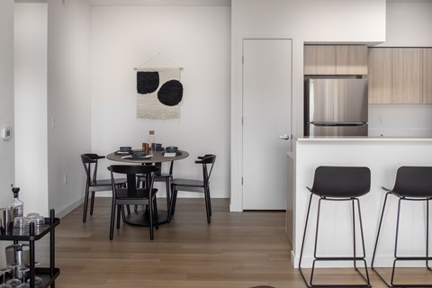 A modern dining area with a black table and chairs at The Arvon, Vancouver, WA