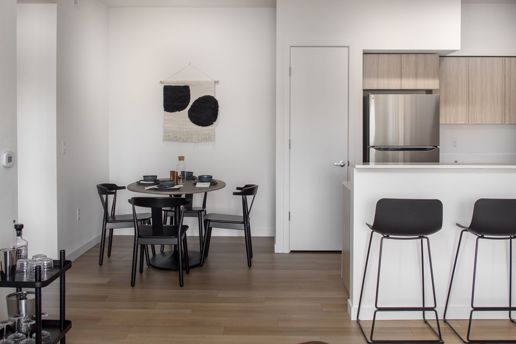 A modern dining room with a black table and chairs.