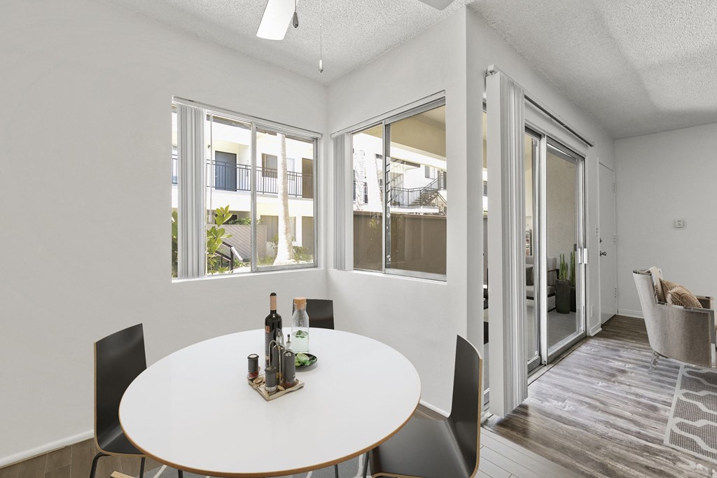 a dining room with a white table and chairs and sliding glass doors at Pacific Rose, Los Angeles, CA 90034