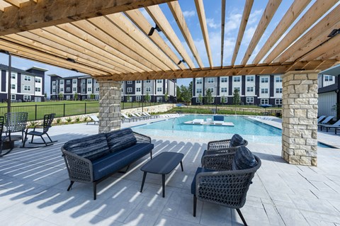A patio with a pool and furniture.