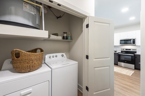 A white washing machine and dryer are in a small laundry room.