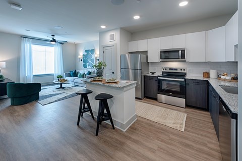 A modern kitchen with a bar stool in front of it.