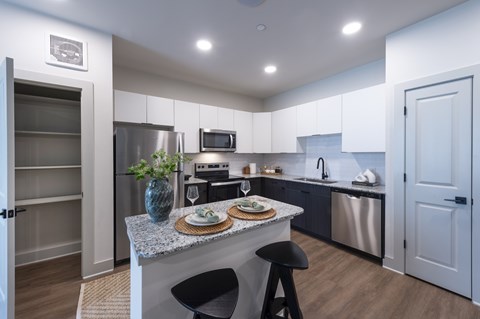 A kitchen with a table and chairs in the middle.