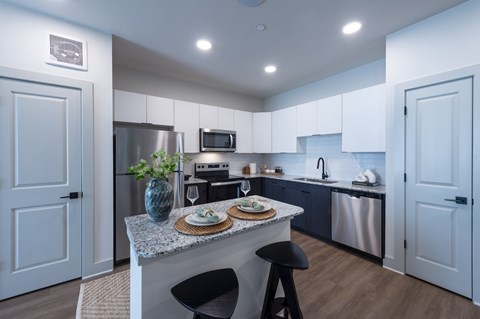 A kitchen with a table and chairs in the middle.
