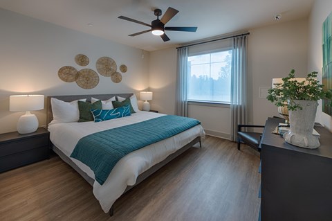 A bedroom with a large bed and a ceiling fan.