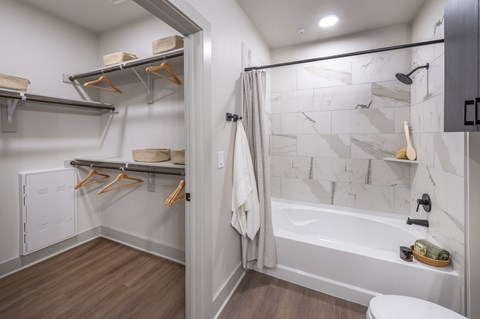 A bathroom with a white tub and a white toilet.