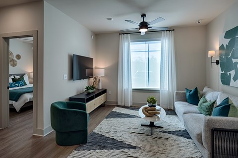A living room with a green chair and a white couch.