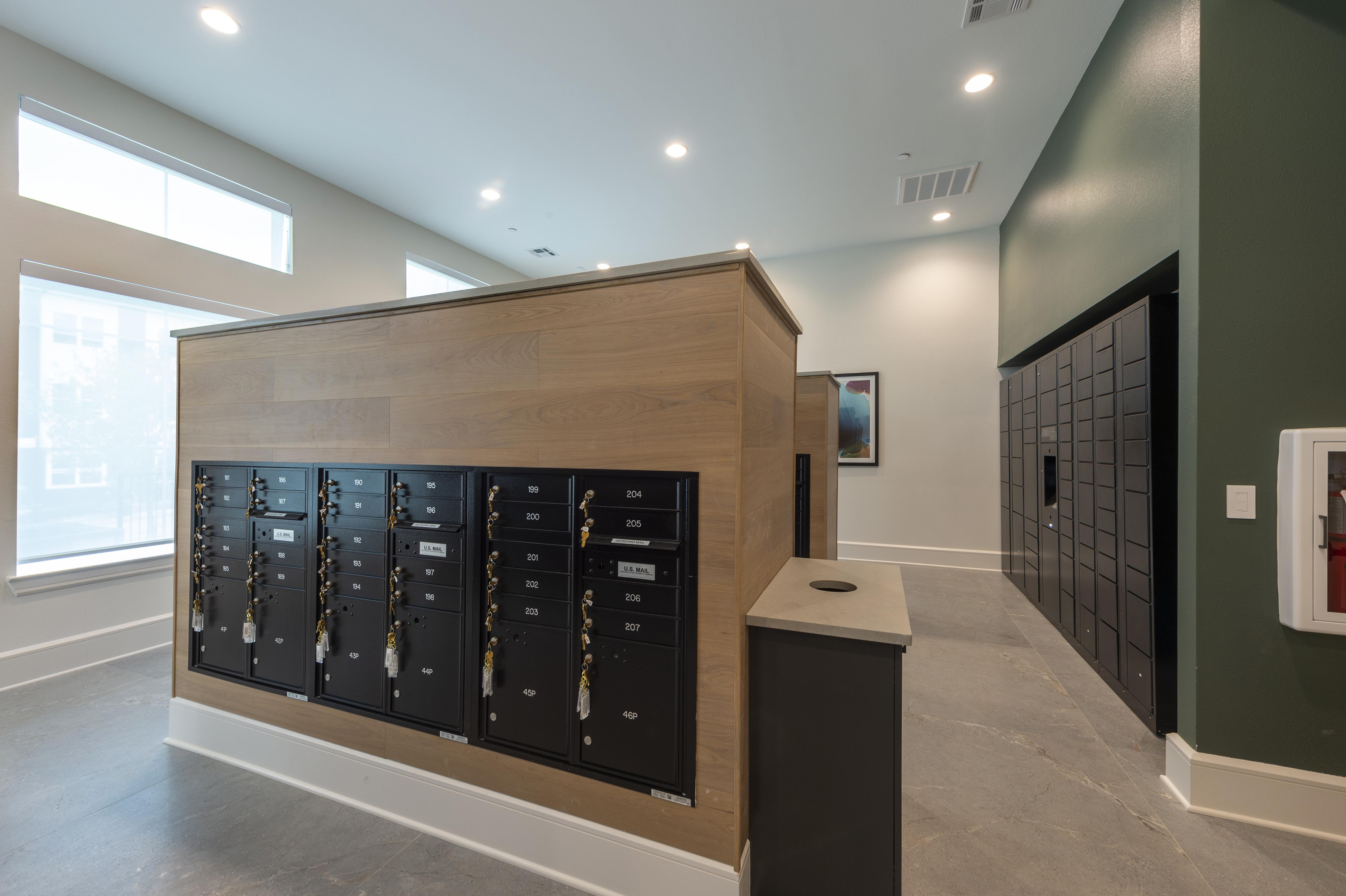 A long wooden cabinet with black drawers is in a room with a grey floor.