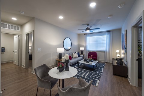 A modern living room with a white table and grey chairs.