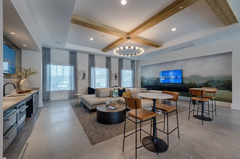 A modern living room with a kitchen area and a television.