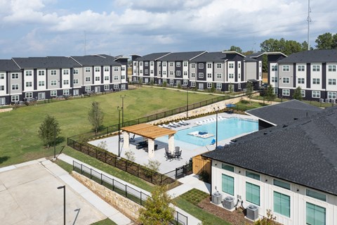 A large apartment complex with a pool and a covered patio area.