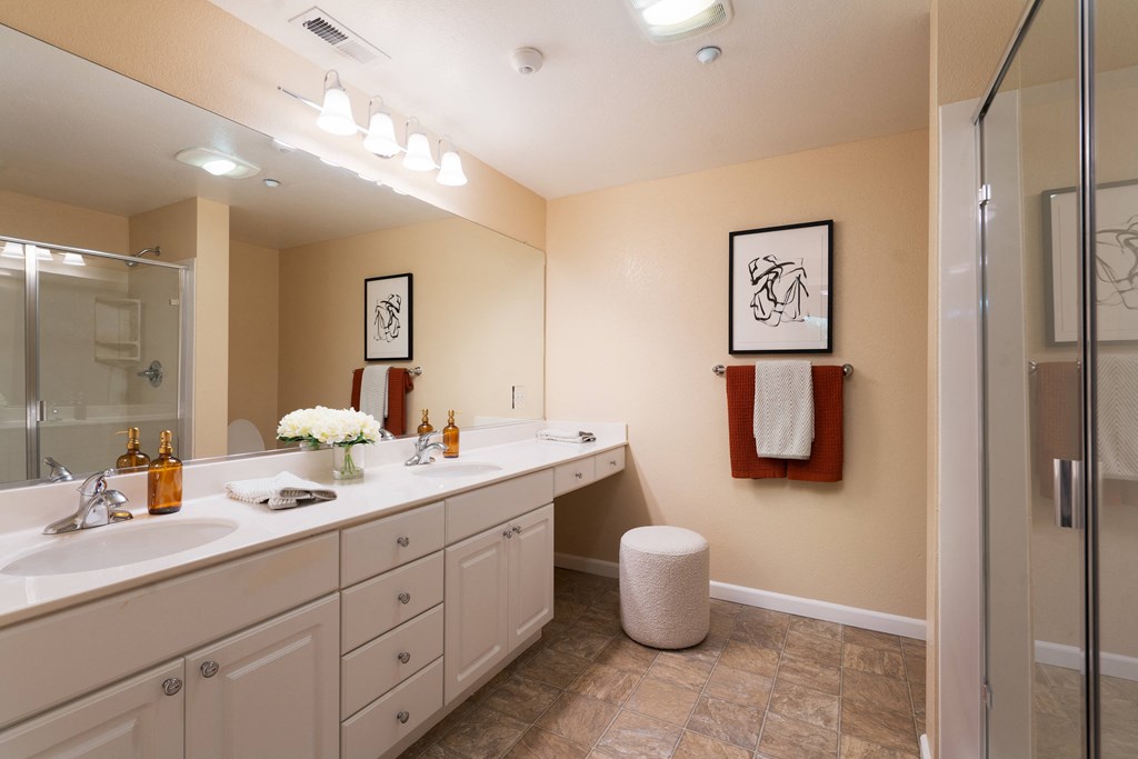 a large bathroom with two sinks and a shower