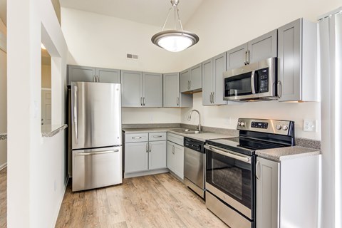 A kitchen with stainless steel appliances and wooden floors.