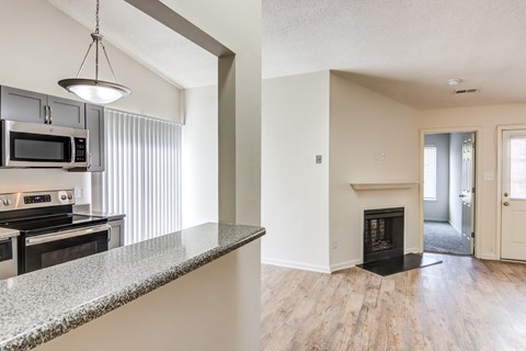 A kitchen with a granite countertop and a stove top oven.