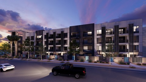 A modern apartment building with cars parked in front.